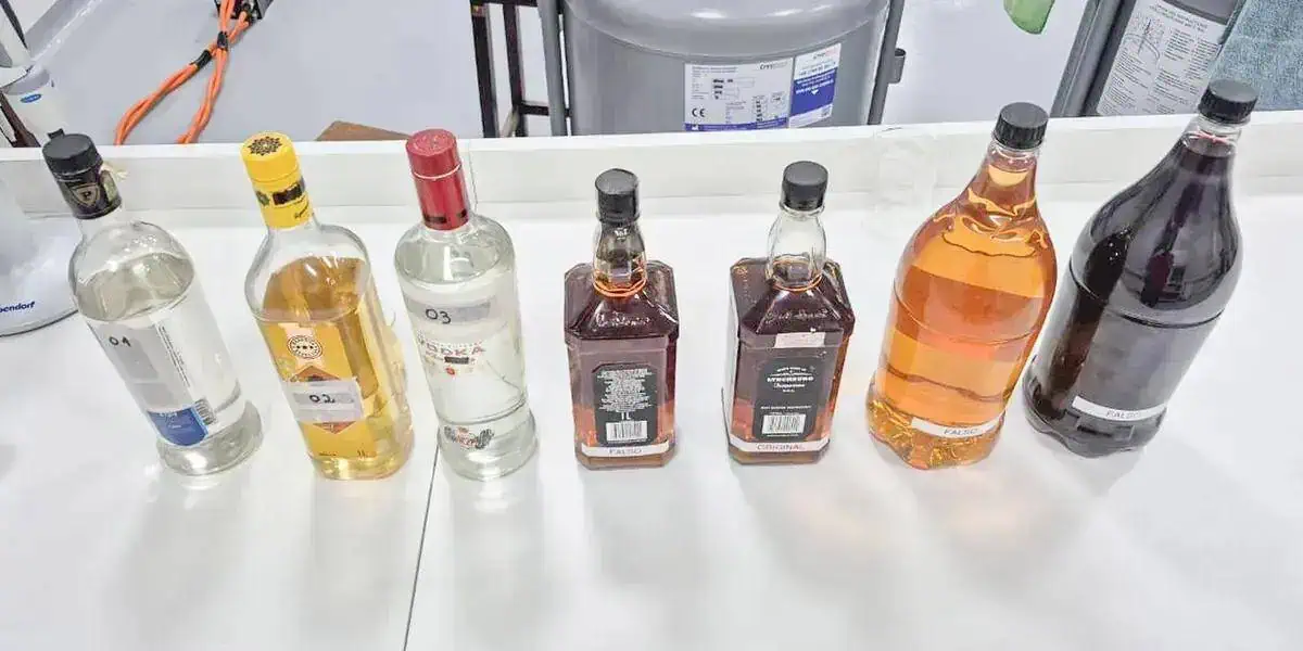 Álcool e bebidas alcoólicas sob inspeção em laboratório de fiscalização de bebidas ilícitas.