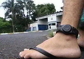 Mão de pessoa usando smartwatch na rua, foco em acessório de fitness e tecnologia portátil.