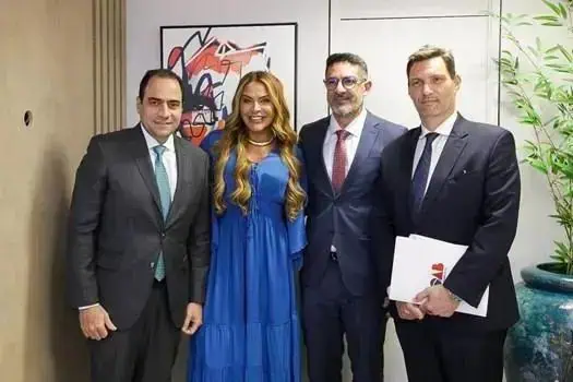 Homens e mulher de terno e vestido posando para foto em ambiente profissional, mostrando destaque em notícias de direito e notícias jurídicas, com foco em eventos legais e advogados.