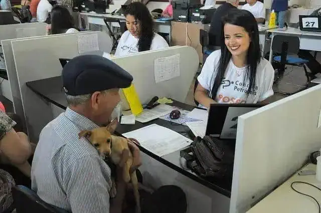 Cidadão com cachorro participa de atendimento em escritório de advocacia, demonstrando inclusão e acessibilidade em serviços jurídicos.
