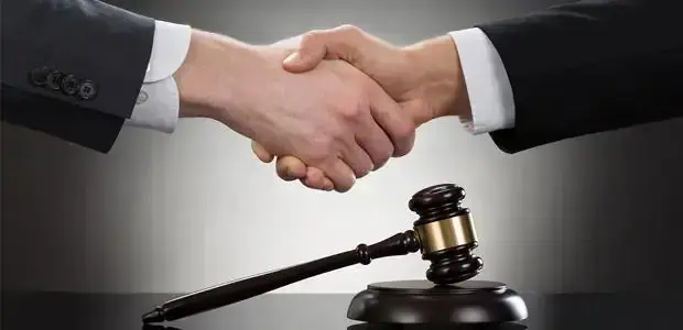 Acordo de mãos dadas entre profissionais de direito, símbolo de ética e justiça no setor jurídico.
