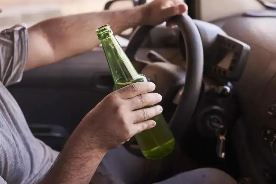 Beber cerveja ao volante, consumo de álcool, direção sob efeito de álcool, perigo no trânsito, segurança viária.