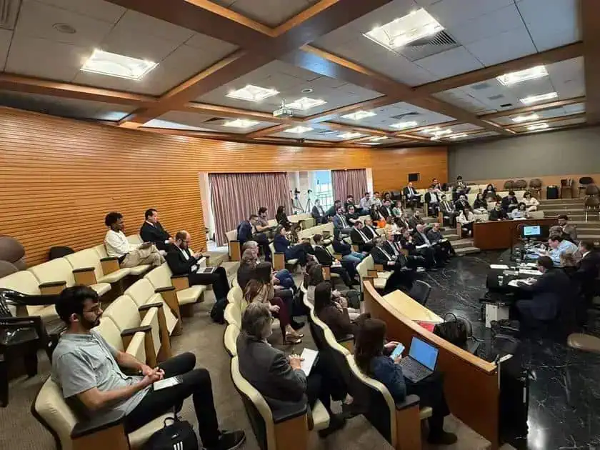 Reunião de profissionais do direito em evento jurídico com audiência e painel de debates, promovendo troca de conhecimentos e atualizações comentando temas de interesse na área jurídica.