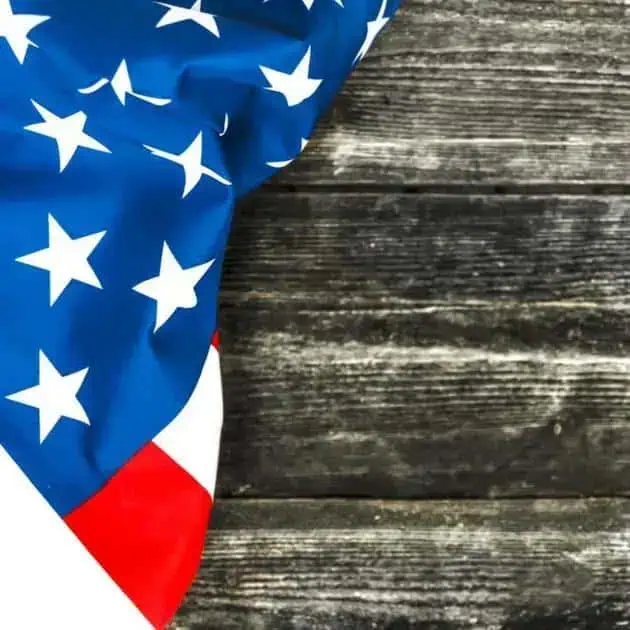 US flag draped on a weathered wooden surface, symbolizing patriotism, national identity, or American values. Ideal for content related to u.s. law, politics, or national news.