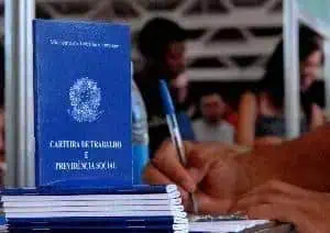 Certidão de nascimento e documentos legais em um balcão de cartório, com pessoas no background, oferecendo serviços jurídicos relacionados a direitos civis.