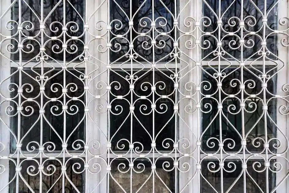 Proteção de janela com grades de ferro, segurança para residências e estabelecimentos comerciais, foco em segurança patrimonial, portões e cercas de proteção.