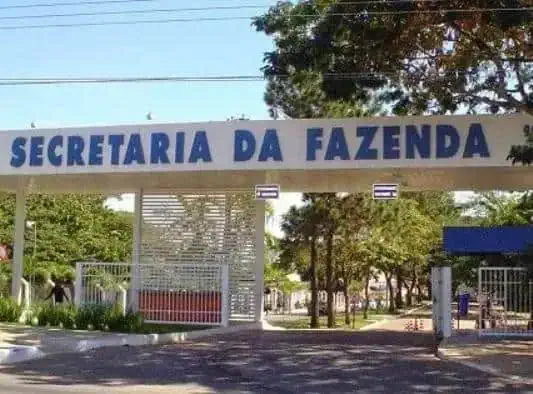 Secretaria da Fazenda chamada de entrada principal em uma prefeitura, ambiente externo com árvores e cerca, destaque para o setor financeiro no contexto de direito e administração pública.