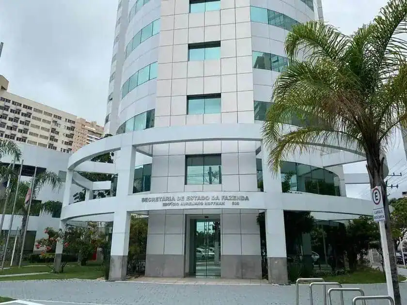 Secretaria da Fazenda, órgão público, prédio moderno, fachada de vidro, edifício governamental, ambiente de trabalho oficial, local de atendimento ao cidadão, saúde financeira pública, notícias de direito, setor público estadual.