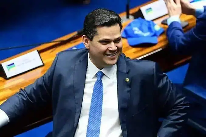 Homem em traje formal sorrindo durante reunião ou evento jurídico, Legislativo ou político, contexto de notícias de direito hoje, destaque em direito e política brasileira.