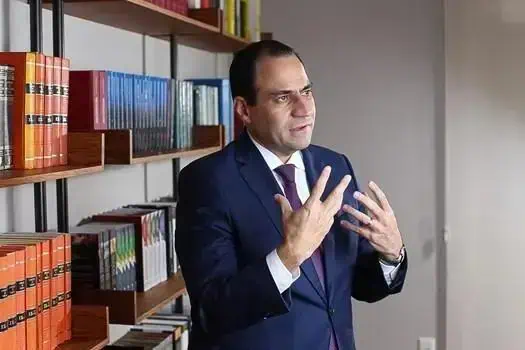 Professor em entrevista na biblioteca, discutindo temas de direito e legislação.