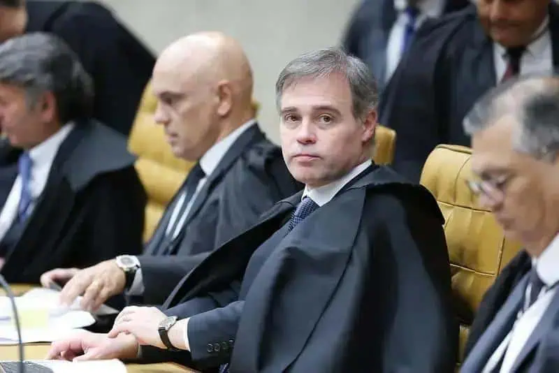 Juiz em tribunal durante sessão de julgamento, ambiente formal e judicial, foco na figura do juiz na cadeira central, relevância para notícias de direito e justiça.