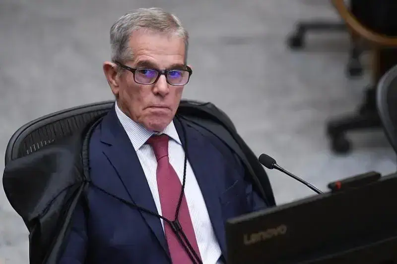 Associação de profissionais do direito em uma audiência judicial com juiz sentado, expressão séria, ambiente de tribunal formal, evidenciando temas de direito, justiça e legislação.