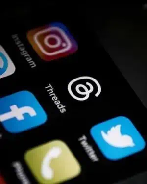 Ícones de redes sociais no smartphone, incluindo Instagram, Facebook, Twitter e WhatsApp, representando comunicação e tecnologia.