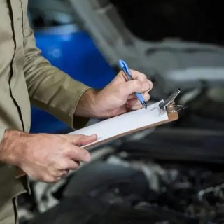 Controle de qualidade e inspeção de veículos em mecânica automotiva, profissional realizando avaliação técnica com prancheta no motor do carro, manutenção preventiva, inspeção técnica automotiva, serviço de revisão automotiva.