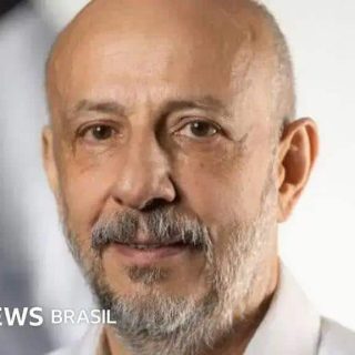 Homem idoso com expressão amigável, cabelos grisalhos e barba, usando camisa branca, em ambiente de entrevista para notícias jurídicas e atualidades, destacando temas do Direito Hoje Notícias.