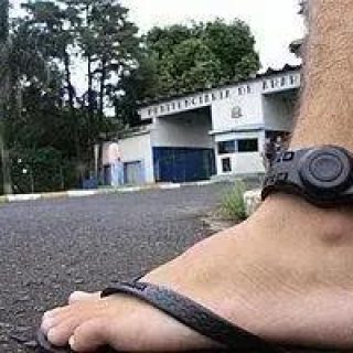 Mão de pessoa usando smartwatch na rua, foco em acessório de fitness e tecnologia portátil.