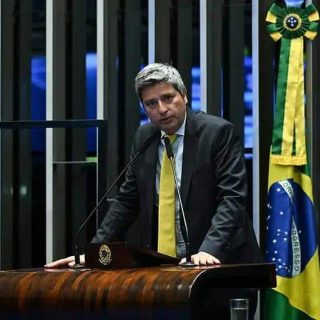 Debatedor no plenário do congresso brasileiro com bandeira do Brasil ao fundo, político em discurso, direito hoje notícias.