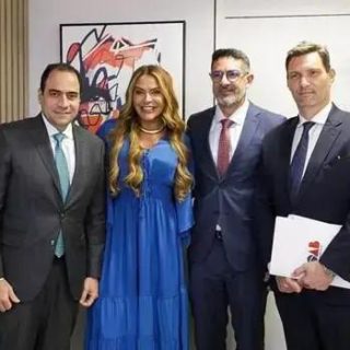 Homens e mulher de terno e vestido posando para foto em ambiente profissional, mostrando destaque em notícias de direito e notícias jurídicas, com foco em eventos legais e advogados.