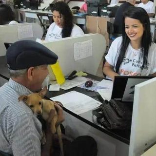 Cidadão com cachorro participa de atendimento em escritório de advocacia, demonstrando inclusão e acessibilidade em serviços jurídicos.