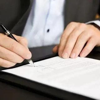 Homem assinando documento oficial em ambiente de escritório, representando ações jurídicas e direitos legais.