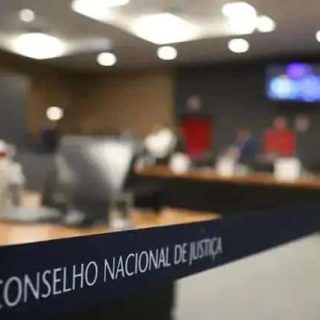 Conselho Nacional de Justiça em sessão de julgamento com ambiente formal e pessoas ao fundo, relacionada às notícias de direito hoje no portal Direito Hoje Notícias.