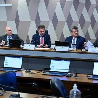 Representantes em reunião do setor jurídico discutindo questões de direito e políticas públicas em um ambiente formal.