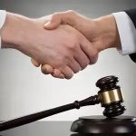 Acordo de mãos dadas entre profissionais de direito, símbolo de ética e justiça no setor jurídico.