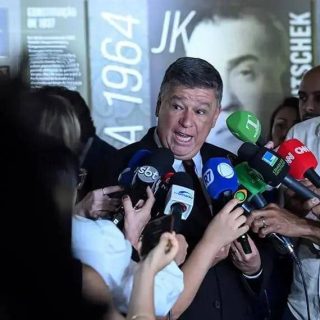 Vereador dando entrevista para a imprensa com vários microfones de canais de notícias diferentes ao seu redor.