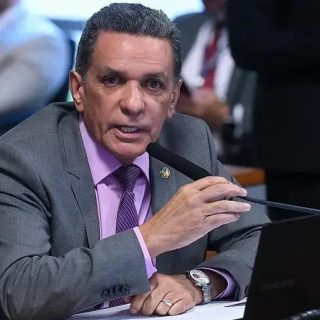 Advogado falando em audiência com microfone em ambiente de tribunal, foco na importância de direito e justiça.