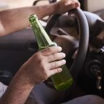 Beber cerveja ao volante, consumo de álcool, direção sob efeito de álcool, perigo no trânsito, segurança viária.