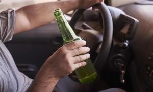 Beber cerveja ao volante, consumo de álcool, direção sob efeito de álcool, perigo no trânsito, segurança viária.