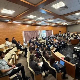 Reunião de profissionais do direito em evento jurídico com audiência e painel de debates, promovendo troca de conhecimentos e atualizações comentando temas de interesse na área jurídica.