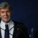 Juiz de direito em tribunal, vestindo terno e gravata, durante sessão de julgamento com foco na área jurídica e notícias de direito hoje.