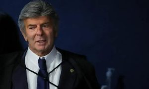 Juiz de direito em tribunal, vestindo terno e gravata, durante sessão de julgamento com foco na área jurídica e notícias de direito hoje.