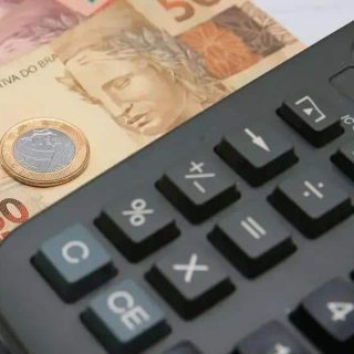 Cédula de moedas de real e cédula de contas com calculadora em fundo de linhas, símbolo de economia e finanças no contexto de notícias e direito financeiro.