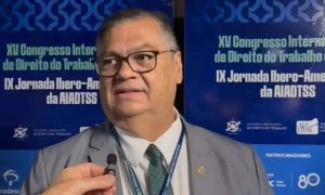 Direito Hoje Notícias, participante fala durante congresso internacional de direito do trabalho na AIADTSS, eventos relevantes sobre direito do trabalho e direitos humanos.