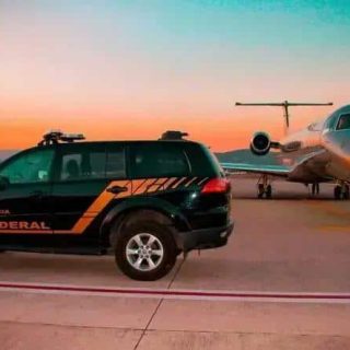 Polícia federal abordando jatinho de luxo em pista de aeroporto ao pôr do sol, destacando segurança e investigação criminal.