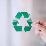 Reciclagem de papel com símbolo de reciclagem verde, representação de sustentabilidade e meio ambiente.