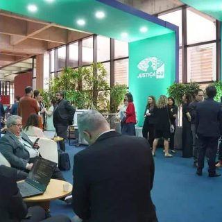 Direito Hoje Notícias, evento com público discutindo temas de justiça e direito em ambiente moderno e profissional, com destaque para a marca Justiça 40.