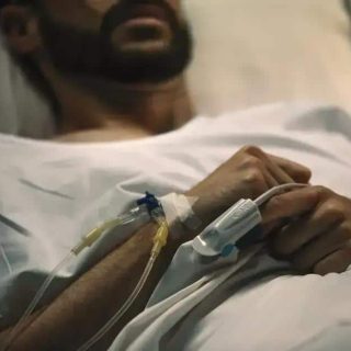 Paciente em estado grave recebendo cuidados médicos em hospital.