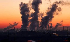 Poluição industrial com fumaça saindo de fábricas ao entardecer, impacto ambiental e questões jurídicas relacionadas à proteção do meio ambiente no Brasil.