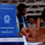 Certidão de nascimento e documentos legais em um balcão de cartório, com pessoas no background, oferecendo serviços jurídicos relacionados a direitos civis.
