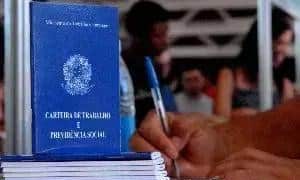Certidão de nascimento e documentos legais em um balcão de cartório, com pessoas no background, oferecendo serviços jurídicos relacionados a direitos civis.