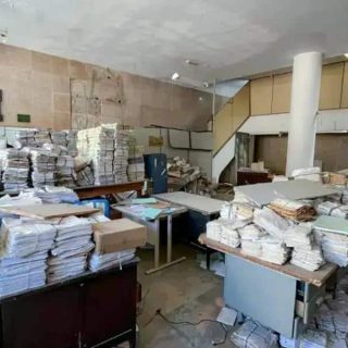 Pilhas de processos jurídicos amontoados em escritório de advocacia, simbolizando excesso de documentação e necessidade de organização em escritórios de direito.