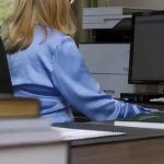 Segurança no ambiente de trabalho, com foco em legislação e direitos trabalhistas, representada por uma profissional utilizando computador em escritório.
