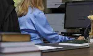 Segurança no ambiente de trabalho, com foco em legislação e direitos trabalhistas, representada por uma profissional utilizando computador em escritório.