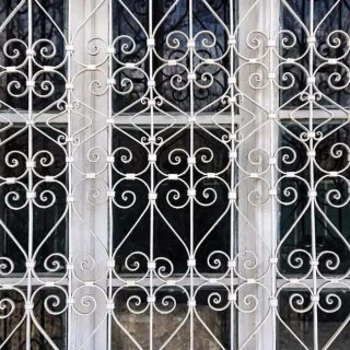 Proteção de janela com grades de ferro, segurança para residências e estabelecimentos comerciais, foco em segurança patrimonial, portões e cercas de proteção.