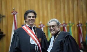 Advogado recebendo homenagem em cerimônia acadêmica no Tribunal de Justiça de Santa Catarina, destacando reconhecimento na área do direito.