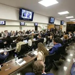 Salão de reunião jurídica com profissionais e advogados participando de um evento ou assembleia.