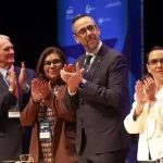 Profissionais do Direito em celebração ao evento jurídico, demonstrando reconhecimento e entusiasmo em ambiente formal de conferência ou seminário.